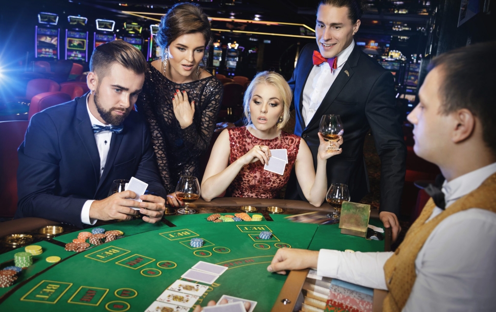 Group of young rich people is playing poker in the casino